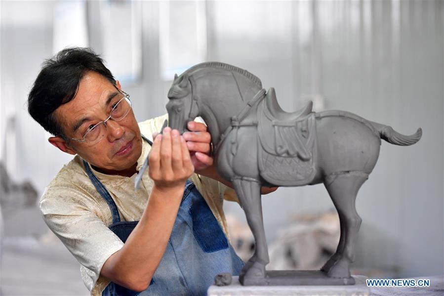 Tri-colored glazed pottery technique inheritor Gao Shuiwang makes a horse pottery in Nanshishan Village, Mengjin County, Luoyang City, central China\'s Henan Province, Aug. 15, 2018. Gao is a leading figure in the revival of tri-colored glazed pottery, or Sancai, a Chinese porcelain characterized by a glaze with three intermingled colours. The producing technique of Sancai, which flourished in the Tang Dynasty (618-907 AD), was very complex and listed as one of China\'s National Intangible Heritages in 2008. Nanshishan Village in Henan is regarded as an important village of Sancai culture, with more than 70 enterprises now engaging in the industry. (Xinhua/Feng Dapeng)