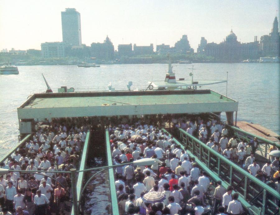 Past: Commuters swarm onboard a ferry on the east bank of the Huangpu River in 1987. Ferries, the only public means of crossing the river in the 1980s, carried more than 1 million people every day at the time. During the rush hour, a vessel could be crammed with as many as 1,400 people.
