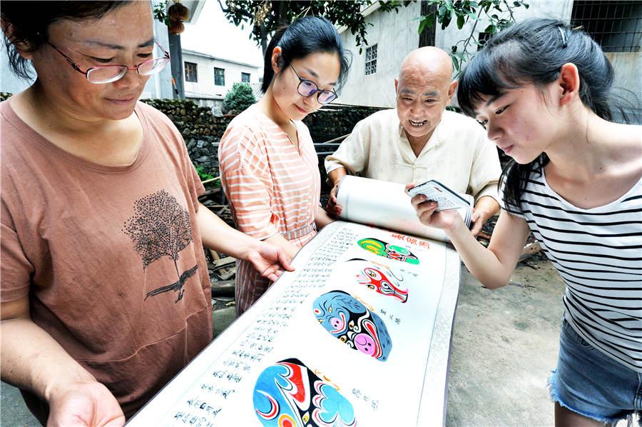 Zhao Xichun shows off his Peking Opera mask scroll in his workshop in Shaorao city, Jiangxi Province on Sept. 2, 2018.  (Photo/Asianewsphoto)