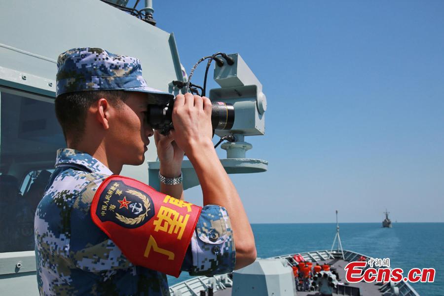 A Chinese soldier watches through a telescope onboard Chinese frigate Huangshan during Exercise KAKADU 2018 at sea off the coast of Darwin, Australia, Sept. 6, 2018. The joint exercise was hosted by the Royal Australian Navy and supported by the Royal Australian Air Force. This year\'s event involves the participation of 27 countries, including China, Bangladesh, Canada, Chile, France, India, Indonesia, Japan, New Zealand, Philippines, Republic of Korea. (Photo: China News Service/Xu Guang)