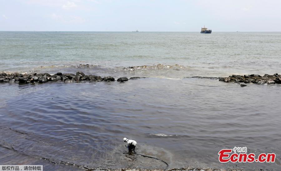 A member of the Sri Lankan coast guard removes oil from a beach after an oil spill in Uswetakeiyawa, Sri Lanka, Sept. 10, 2018. (Photo/Agencies)
