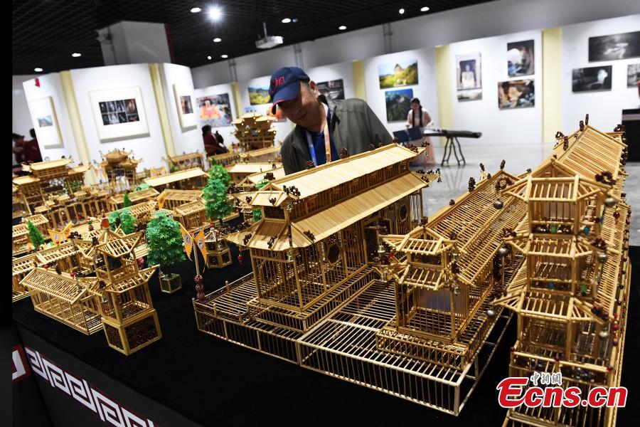 Craftsman Wu Tianxiang shows a replica of Fuxi Temple in Tianshui City made using bamboo sticks during the Silk Road (Dunhuang) International Cultural Expo in Dunhuang City, Northwest China’s Gansu Province, Sept. 28, 2018. It took Wu five years and 20,000 bamboo sticks to create the miniaturized landscape that measured 4.8 meters long and 4.2 meters wide and included 58 buildings in great details. Each door and window in the model can be opened easily. (Photo: China News Service/Yang Yanmin)