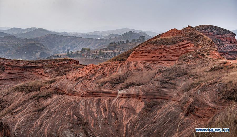 Photo taken on Oct. 21, 2018 shows a view of Danxia landform at Wangjiawan of Pingqiao Town in Ansai District of Yan\'an, northwest China\'s Shaanxi Province. Danxia landform is a unique type of geomorphology formed from red-colored sandstones and characterized by steep cliffs. (Xinhua/Tao Ming)
