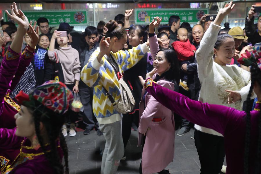 People dance at the night food market in Hotan city in Northwest China\'s Xinjiang Uygur autonomous region, Oct. 22, 2018. (Photo/chinadaily.com.cn)