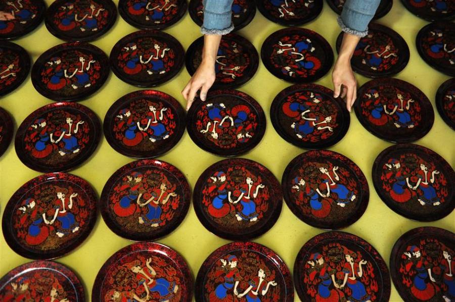 Newly painted lacquer plates are laid out for natural drying at the High Sheen Yi-ethnic Style Lacquerware Factory in Dafang County, southwest China\'s Guizhou Province. (Photo/Xinhua)
Regarded as one of “the three specialties of Guizhou” along with the bamboo flute and the province’s signature white wine, Dafang lacquerware is known over the world for its delicacy and beauty.
The history of the art form can be traced back more than 600 years to when a sophisticated process was developed during Ming Dynasty (1368-1644).