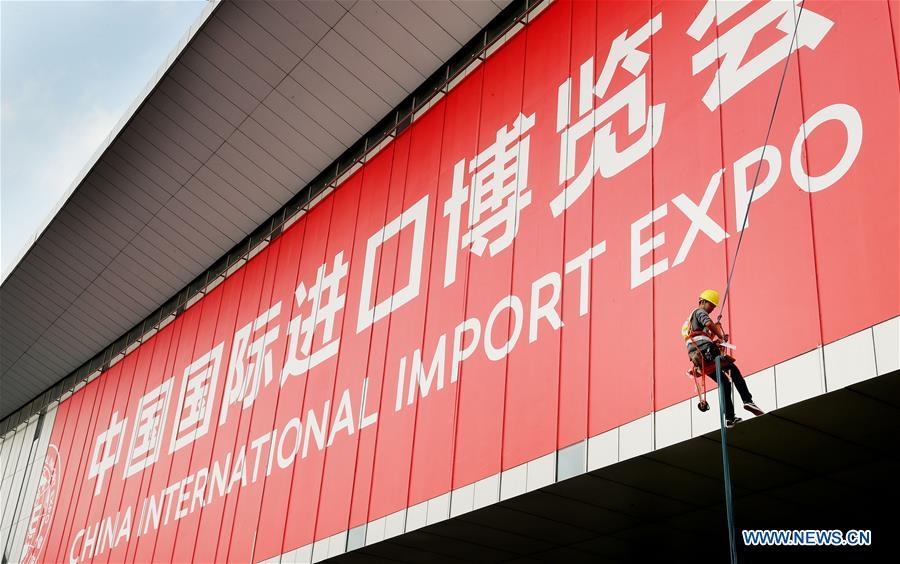 A worker pastes a sign poster for the upcoming China International Import Expo (CIIE) at the National Exhibition and Convention Center in Shanghai, east China, Oct. 26, 2018. The exhibition booth arrangement work for the CIIE has begun in Shanghai, the organizer said Thursday. Over 1,800 exhibition booths will be set up by the end of the month, before exhibitors start to display products on Nov. 1 and 2, according to the China International Import Expo Bureau. (Xinhua/Fang Zhe)