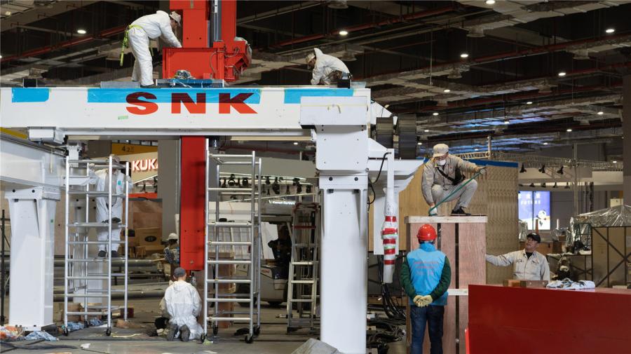 Workers install the platform for SNK, a Japanese video game hardware and software company, at the National Exhibition and Convention Center (Shanghai) on Oct. 28. (Photo/chinadaily.com.cn)