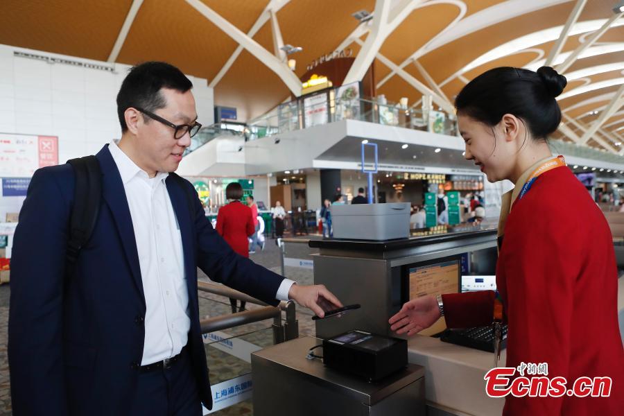 Passenger Zhang Lian, set to board a Cathay Pacific flight from Shanghai to Hong Kong, uses just a QR code to complete security and check-in procedures in approximately 10 minutes at Shanghai Pudong International Airport, Oct. 29, 2018. The airport is the first Chinese mainland airport to adopt paperless check-in for outbound passengers. (Photo: China News Service/Yin Liqin)