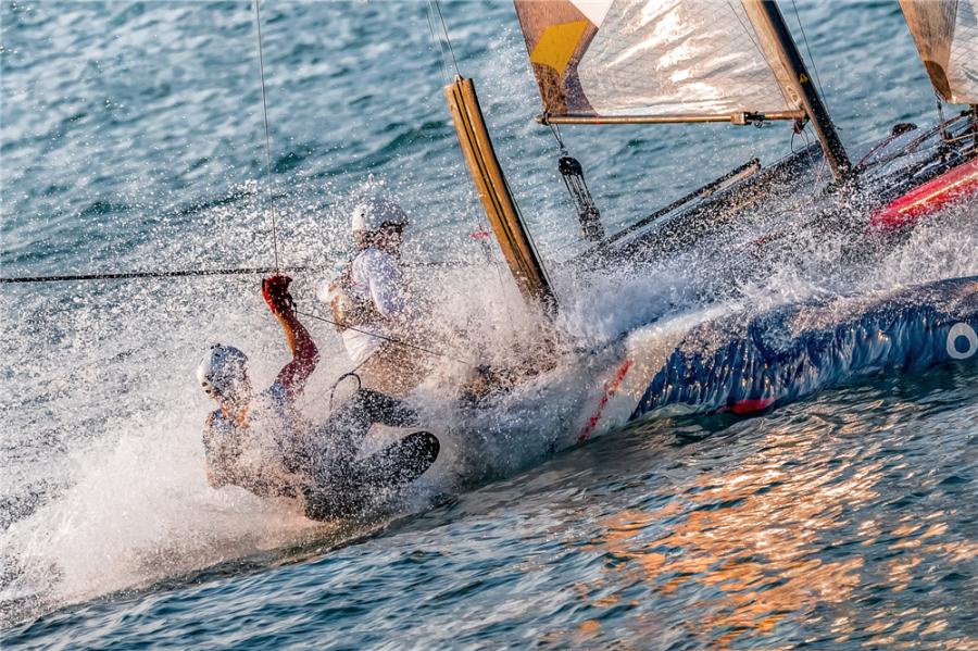 Sailors steer a two-man catamaran as water splashes during the 2018 Extreme Sailing Series Qingdao Mazarin Cup. (Photo by Zhong Weihua/for chinadaily.com.cn)
The 2018 Extreme Sailing Series Qingdao Mazarin Cup unveiled on Wednesday the award-winning photography of the event.
Selected through a contest, the photos captured moments from the 12-strong international Flying Phantom fleet during the sailing competition in Qingdao, Shandong Province, held from Sept. 30 to Oct. 3.
The Extreme Sailing Series, established in 2007, is the original Stadium Racing sailing circuit designed for spectators, delivering high-performance action close to the shore and putting guests at the heart of the battle.
The event has bolstered the coastal city of Qingdao\'s reputation as the home of Chinese sailing.