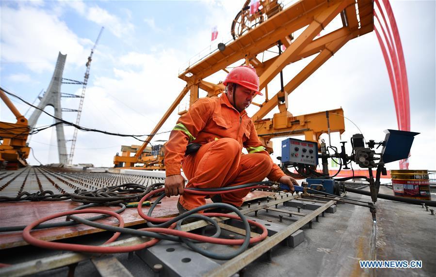 A man works at the construction site of Puqian Bridge in south China\'s Hainan Province, Nov. 3, 2018. The closure of the main bridge of Puqian Bridge spanning a geological fault line was finished on Saturday. (Xinhua/Guo Cheng)
