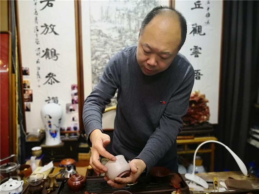 Zhao Qiushi presents a microscopic carving work on a tea cup. (Photo/chinadaily.com.cn)

In the past 10 years, Zhao Qiushi has created more than 2,000 pieces of microscopic carvings in Changchun, capital city of Northeast China\'s Jilin Province.

Zhao, 46, who runs an artwork studio in Changchun, created his first piece upon a customer\'s request in 2009.

The artist, who learned the traditional Chinese artistic techniques in university, provided the customer within five days a 30-millimeter stone ornament carved with the Heart Sutra, a popular Buddhist scripture which includes 260 Chinese characters.

Since then, he has been engaged in creating such carvings of Chinese classical literature works.

His most exquisite work is a piece of 2-square-centimeter stone caved with the Heart Sutra.

\
