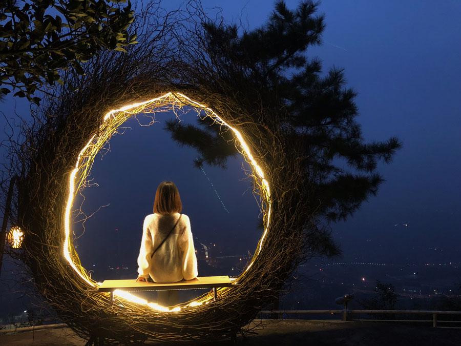 A visitor takes a picture inside the Bali bird nest at Chongqing Night View Park on Nov. 10, 2018. (Photo provided to chinadaily.com.cn)

A themed park featuring night scenes recently opened to the public on Nanshan Mountain in Chongqing, a city in Southwest China also surrounded by the Yangtze and Jialing rivers.

Visitors to Chongqing Night View Park can enjoy a 270-degree panorama view of the two rivers and the Yuzhong Peninsula. The park features seven themed photo spots, such as a giant bird nest, a Bali bird nest, a dream kitchen, a heart house and star bubble house.

The park attracted a lot of visitors since opening Nov. 10, and some young people have even proposed at the Star bubble house, according to park staff.