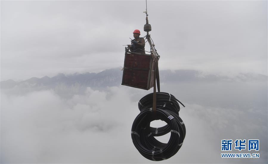 A water exploration team member uses an iron basket to transport water pipes to the Tianbao cave in Tianfengping village, Enshi city, Central China\'s Hubei Province, Nov. 13, 2018. (Photo/Xinhua)

Every year from October to March, when rainfall decreases, Tianfengping, a poor village which lies under a cliff in Enshi city, Central China\'s Hubei Province, faces a water shortage.

Each year during the water shortage, nearly 800 villagers search for water. In October, a water exploration team was formed and finally discovered a water source within the cliff in Tianbao cave.

After a month of hard work, villagers are now drawing fresh spring water from the cave and should be able to drink the water before Chinese New Year, which is Feb. 5.