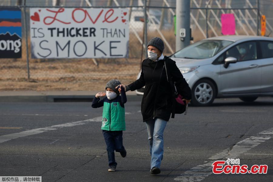 Leanne Brickett and her son, Aiden, 5, wear masks to protect themselves from smoke from the Camp Fire in Chico, California, U.S., November 18, 2018. (Photo/Agencies)