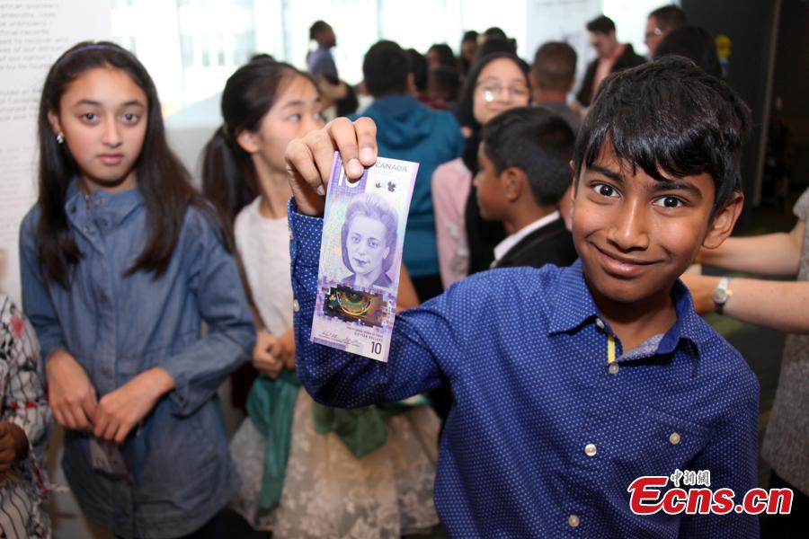 A boy holds a $10 banknote featuring Viola Desmond in Toronto, Canada, Nov. 19, 2018. The banknote is the first vertically oriented bill in Canada and the first regularly circulating banknote to feature a Canadian woman, civil rights advocate Viola Desmond, on the front. (Photo: China News Service/Yu Dongrui)