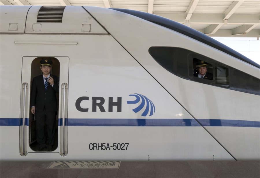 A train engineer peers out the door of the CRH5A high-speed train in Hunchun city, Northeast China\'s Jilin Province, April 27, 2018. (Photo provided to chinadaily.com.cn)