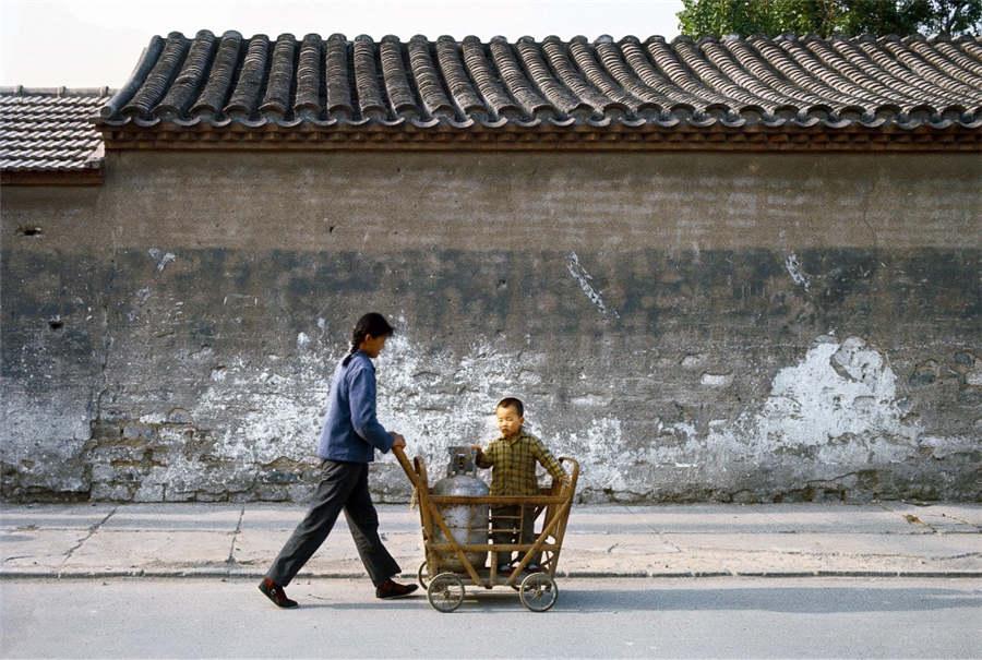 A woman pushes a child in a cart in Beijing, 1979. (Photo provided to chinadaily.com.cn)