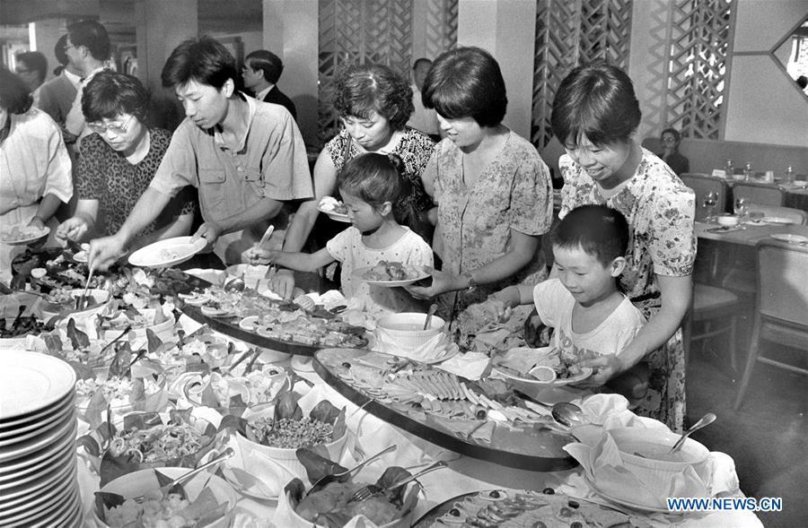 File photo taken in 1990 shows people selecting western food at a restaurant in Suzhou, east China\'s Jiangsu Province. From 1978 when China started its reform and opening-up policy, a door to the outside world has been opened. Along with the imported commodities, fashion ideas inevitably slipped into China and since then the country, which was somewhat lack of fashion diversity, started its journey to pursue fashions. Over the past four decades, the thirst for beauty has driven Chinese people to pursue every possible fashionable element. The change first came with dress when colorful and diversified clothing prevailed as against the former dominant blue and grey. For a time, men and women raced to hairdressers\' just for trendy hairdos. Eating McDonald\'s or western cuisine even once was regarded as a fashionable thing. However, the most conspicuous change is that Chinese people have become more inclusive and they tend to accept new fashions, styles and concepts. China nowadays is dazzling the world not only on the fashion stage but in many other fields. Changes in fashions, as a profile of society, has well interpreted the benefits to people brought by China\'s reform and opening-up policy. (Xinhua/Fang Ailing)