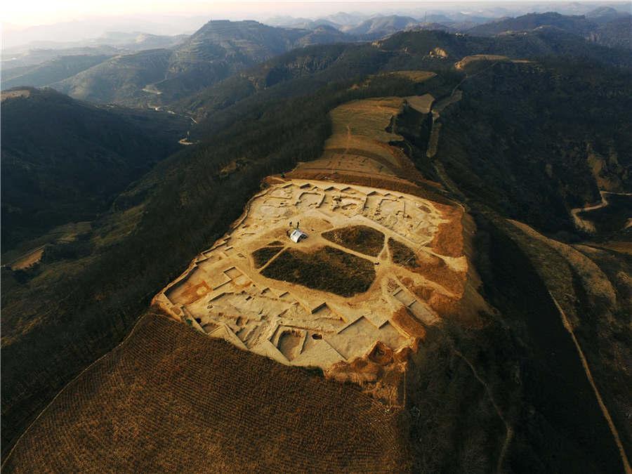 An aeriel view of the Lushanmao historic relics site in the Baota district of Yan\'an city, Northwest China\'s Shaanxi Province. (Photo provided to chinadaily.com.cn)
Archaeologists said the Lushanmao historic relics site in the Baota district of Yan\'an city, Northwest China\'s Shaanxi Province, could be the country\'s prototype for early palaces.
Experts from the Shaanxi Provincial Institute of Archeology recently found a foundation of rammed earth, on which there could have been a neatly arranged courts, walls and architectural complex.
Jadeware was found in the foundations of some buildings.
The site, covering an area of two million square meters, is one of the largest prehistoric settlement sites in China. A large number of historical relics including pottery, stoneware, boneware and jadeware have been unearthed at the site previously.
Based on features of the unearthed artifacts, the site\'s history can be traced back around 4,500 years, according to experts.