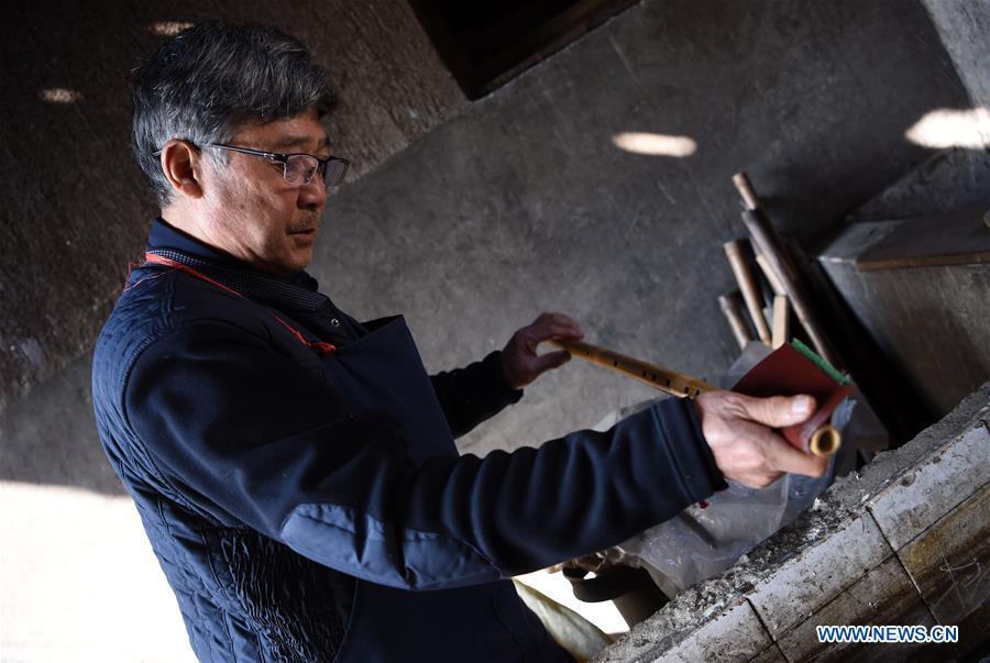 Liu Zesong, inheritor of the Yuping bamboo flute making craft, deals with bamboo materials for making a flute in Yuping Dong Autonomous County, southwest China\'s Guizhou Province, Nov. 29, 2018. As a traditional Chinese bamboo instrument, Yuping bamboo flute is famous for its clear tone and delicate carving. Made from local bamboo, the flute goes through dozens of procedures before finished and merges folk cultures of other ethnic groups. It was listed as one of the National Intangible Cultural Heritages in 2006. (Xinhua/Ma Ning)