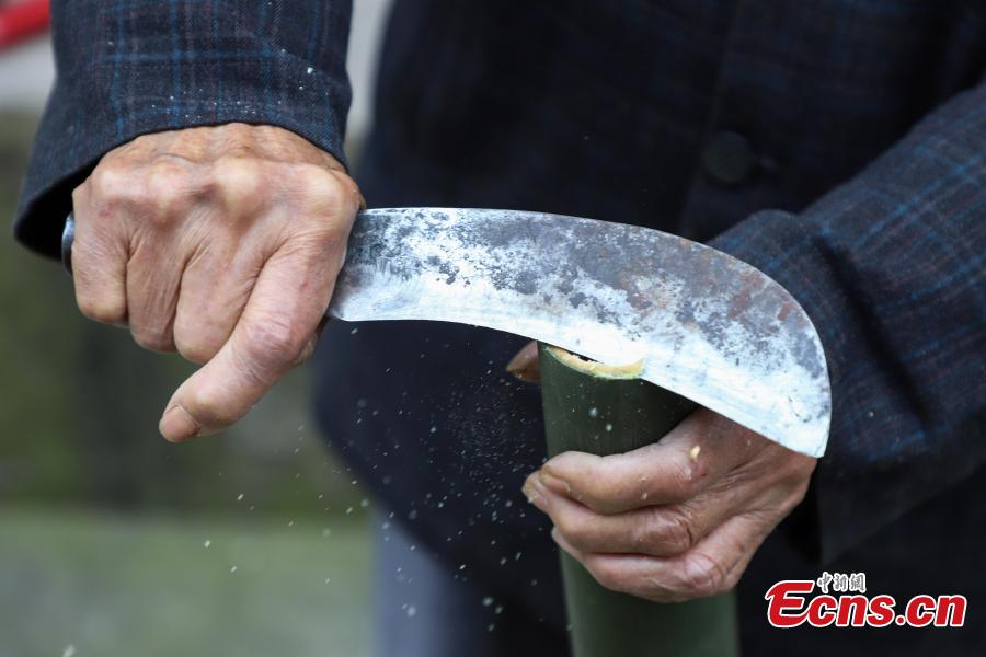78-year-old Song Erfeng chops bamboo into long and thin filaments in preparation for materials to make bamboo hats in a village in Tangtou town, Southwest China\'s Guizhou province on December 3, 2018. As an inheritor of bamboo hat making skills, Song has been practicing the craft for 70 years. Being made with bamboo filaments as thin as hair, the special hat has a history that can be traced back to Ming Dynasty (1368-1644). (Photo: China News Service/ Qu Honglun)