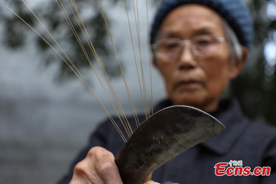 78-year-old Song Erfeng chops bamboo into long and thin filaments in preparation for materials to make bamboo hats in a village in Tangtou town, Southwest China\'s Guizhou province on December 3, 2018. As an inheritor of bamboo hat making skills, Song has been practicing the craft for 70 years. Being made with bamboo filaments as thin as hair, the special hat has a history that can be traced back to Ming Dynasty (1368-1644). (Photo: China News Service/ Qu Honglun)