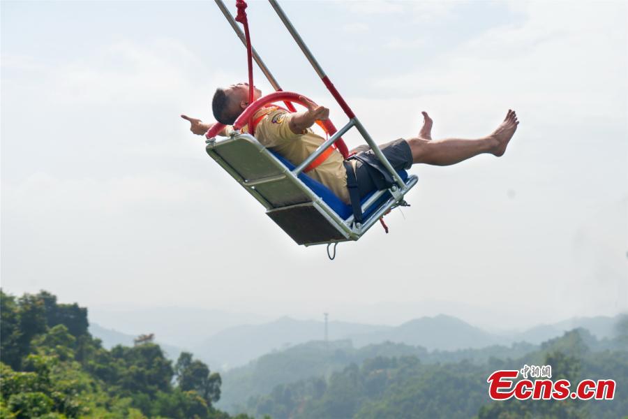 Photo shows a tourist experiencing the cliff swing that officially opened to the public in Qingyuan, Guangdong Province on December 19, 2018. The swing above a 198-meter waterfall on Mount Tianzi in Qingyuan, South China\'s Guangdong Province officially opens on Thursday after a four-month trial operation. (Photo: China News Service/Cheng Jingwei)