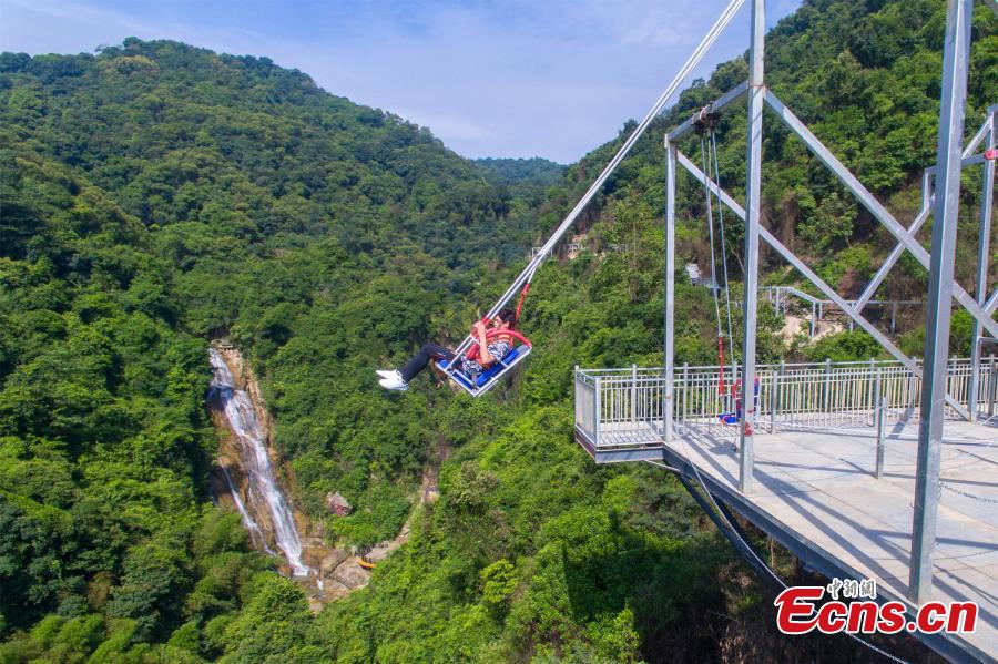 Photo shows a tourist experiencing the cliff swing that officially opened to the public in Qingyuan, Guangdong Province on December 19, 2018. The swing above a 198-meter waterfall on Mount Tianzi in Qingyuan, South China\'s Guangdong Province officially opens on Thursday after a four-month trial operation. (Photo: China News Service/Cheng Jingwei)
