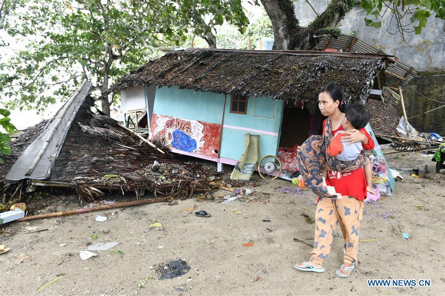 A woman holding her child walks by debris of a kiosk near the beach in Carita after a tsunami hit Sunda Strait in Pandeglang, Banten province, in Indonesia, Dec. 23, 2018. The total casualty of a tsunami triggered by the eruption of Krakatau Child volcano has increased to 222 people in coastal areas of Sunda Strait of western Indonesia, disaster agency official said here on Sunday. The catastrophe killed at least 222 people, wounded at least 843 ones and collapsed a total of 556 houses and nine hotels, and caused damages to scores of ships. (Xinhua/Veri Sanovri)