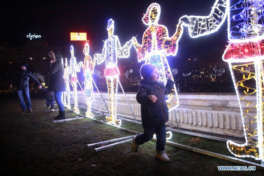 Light installations representing people in traditional costumes dancing Hora of Unity are seen in downtown Bucharest, Romania, on Dec. 24, 2018. (Xinhua/Gabriel Petrescu)