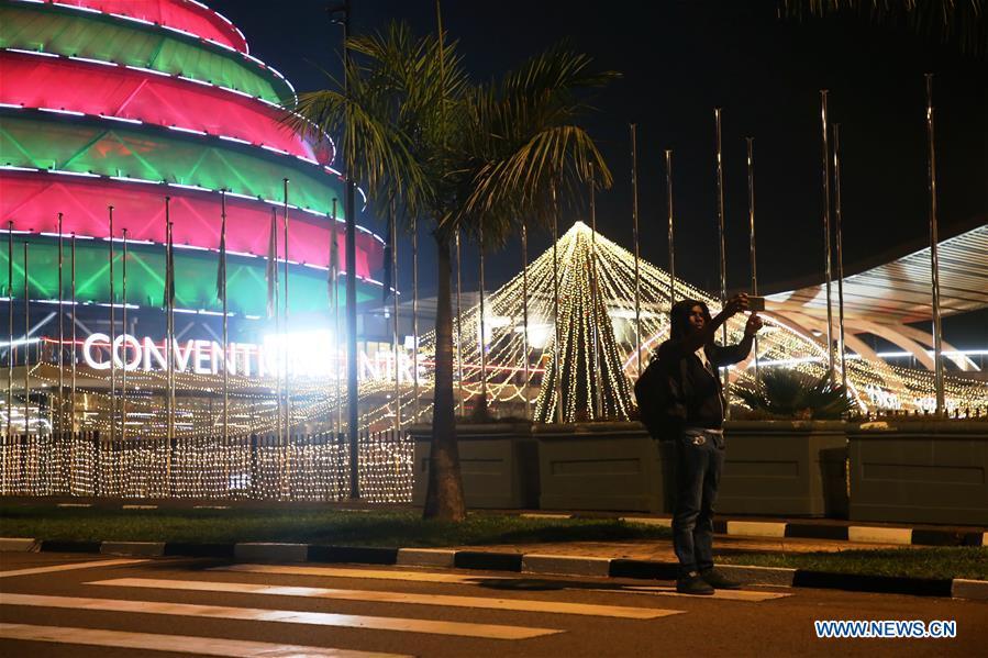 A person poses for a selfie with Christmas light decorations in Kigali, capital of Rwanda, on Dec. 24, 2018. (Xinhua/Lyu Tianran)