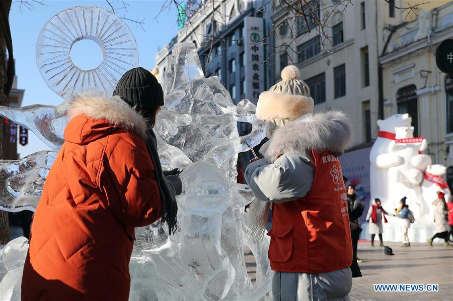 Contestants carve an ice sculpture on the Zhongyang Street during a national college ice sculpture competition in Harbin, capital of northeast China\'s Heilongjiang Province, Jan. 2, 2019. (Xinhua/Cao Jiyang)