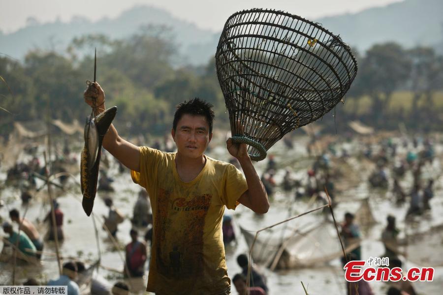 An Indian villager shows his catch as he participates in community fishing as part of Bhogali Bihu celebrations in Panbari village, some 50 kilometers east of Gauhati, India, Jan. 14, 2019. \