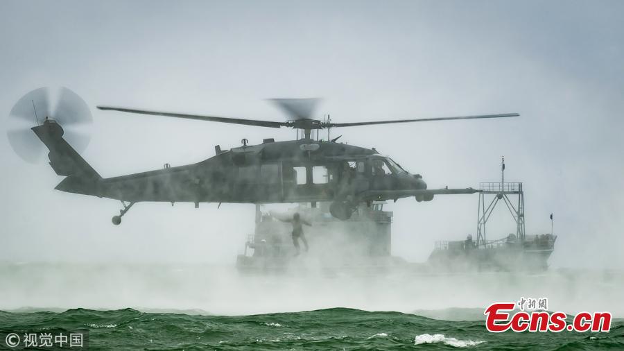 An Air Force Reserve pararescueman from the 920th Rescue Wing jumps out of an HH-60G Pave Hawk helicopter on May 26, 2018 during the 2nd annual Salute to American Heroes Air and Sea Show, in Miami Beach, Fla. (Photo/VCG)