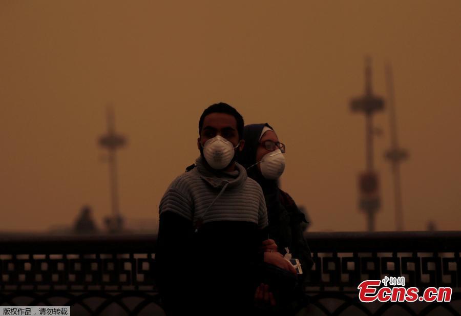 A couple covers their faces with masks during a sandstorm in Cairo, Egypt, Jan. 16, 2019. Egypt\'s capital Cairo and some of its port cities were hit by a severe sandstorm, with strong winds and heavy dust forcing the closure of several ports. (Photo/Agencies)
