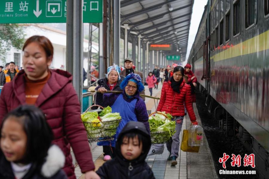 Passengers carrying agricultural products alight a train at Kaili Railway Station in Guizhou Province, Jan. 17, 2019. The railway line linking Guiyang City and Yuping County in Tongren County has been running for 44 years - opening in 1975 - connecting the villages of the many ethnic groups residing deep in the mountains with the outside world. The 342-km journey takes about seven hours - incredibly slow when compared with the speeds of China\'s increasingly ubiquitous bullet trains. (Photo: China News Service/He Junyi)