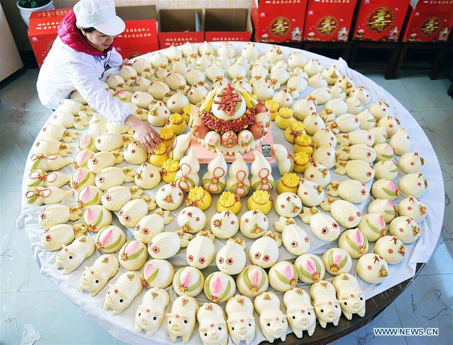 A villager arranges steamed buns made to celebrate the lunar New Year in Shengjiazhuang Village, Jiaozhou City of east China\'s Shandong Province, Jan. 24, 2019. (Xinhua/Wang Zhaomai)