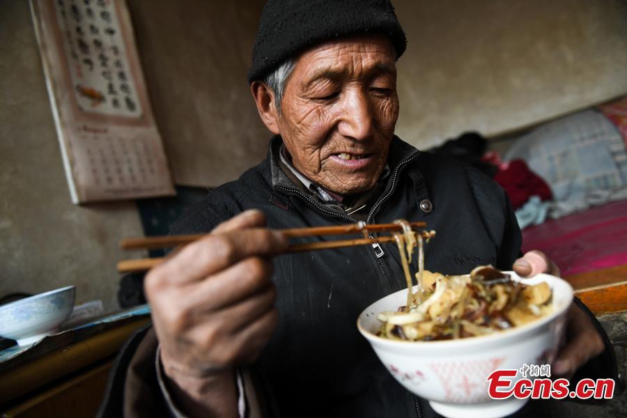 Li Tieliang, 69, has his lunch before returning to work as an extra in a TV drama being shot in Beishanyun Village in Yushe County, North China’s Shanxi Province, Jan. 24, 2019. The village has more than 30 well-preserved buildings from the Ming and Qing dynasties, making it a good location to shoot historical film and TV dramas. In recent years, many locals have migrated to other places, while some remaining farmers have found work as extras. Li and his wife survive by farming, while their children work in other cities. Li now works part-time as an extra and earns about 100 yuan ($14) a day. (Photo: China News Service/Wu Junjie)