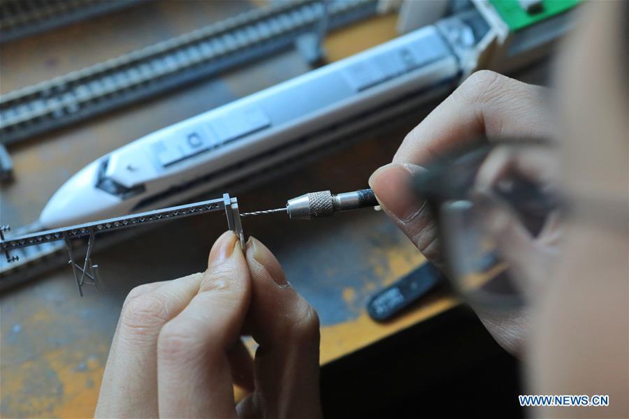 Zhang Yuqi makes a model of a bullet train maintenance center at his home in Guiyang, capital of southwest China\'s Guizhou Province, Jan. 30, 2019. As a model train hobbyist, 27-year-old Zhang Yuqi has made and collected more than a hundred model trains. Zhang is also a bullet train mechanic responsible for checking bullet trains during the Spring Festival travel rush at a maintenance center in Guiyang of Guizhou Province. Despite heavy work load and work pressure, Zhang said he is dedicated to ensuring the safety of bullet trains. (Xinhua/Ou Dongqu)
