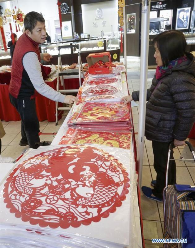 A resident selects paper decorations during the 30th Chinese Lunar New Year Flower & Gift Fair in Richmond, Canada, Jan. 30, 2019. The seven-day Chinese Lunar New Year Flower & Gift Fair, west Canada\'s largest indoor Lunar New Year festivity, was opened on Tuesday. (Xinhua /Liang Sen)
