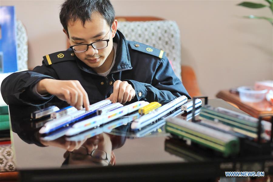 Zhang Yuqi makes model trains at his home in Guiyang, capital of southwest China\'s Guizhou Province, Jan. 30, 2019. As a model train hobbyist, 27-year-old Zhang Yuqi has made and collected more than a hundred model trains. Zhang is also a bullet train mechanic responsible for checking bullet trains during the Spring Festival travel rush at a maintenance center in Guiyang of Guizhou Province. Despite heavy work load and work pressure, Zhang said he is dedicated to ensuring the safety of bullet trains. (Xinhua/Ou Dongqu)