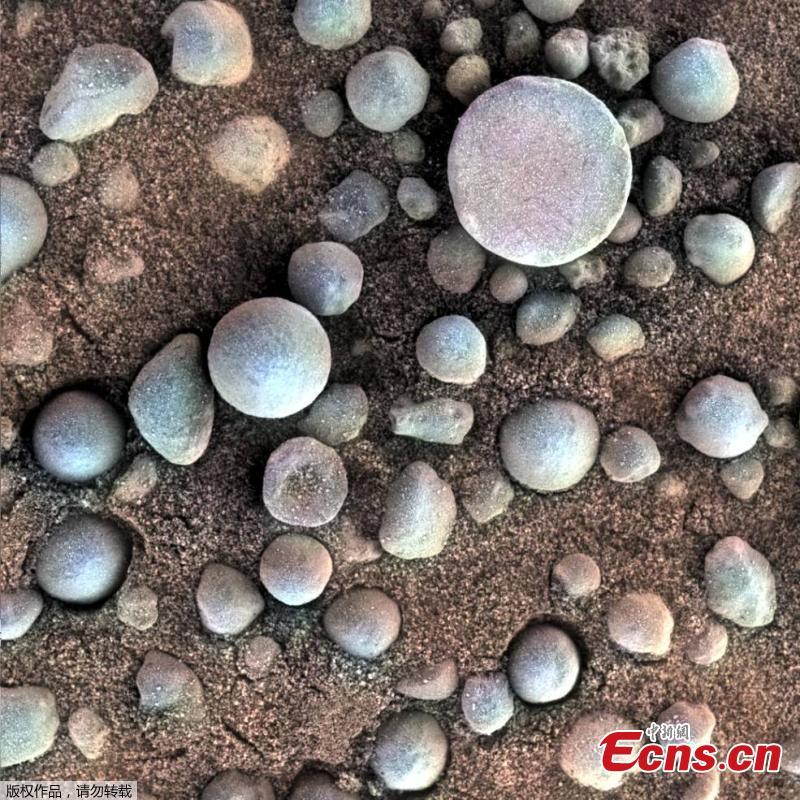 These tiny spherules pepper the sandy surface in this 3-centimeter square view of the Martian surface. Opportunity took this image while the target was shadowed by the rover\'s instrument arm. (Photo/VCG)