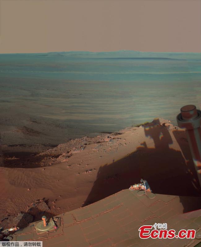 Opportunity catches its own late-afternoon shadow in this dramatically lit view eastward across Endeavour Crater on Mars, May 22, 2012. he scene is presented in false color to emphasize differences in materials such as dark dunes on the crater floor. (Photo/VCG)