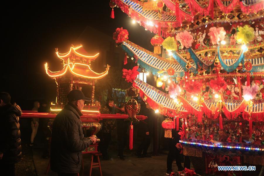 Villagers participate in the ornamental dragon parade in Xiliuzhai Village of Beibaixiang Town of Yueqing, east China\'s Zhejiang Province, Feb. 12, 2019. Having a history of more than 400 years, the ornamental dragon, a sacrifice to pray for good fortune during the period of Lantern Festival, is popular in villages of Yueqing City in Zhejiang Province. Lin Shunkui, an inheritor of the handicraft of ornamental dragon, is born in 1956 in Dongchan Village of Beibaixiang Town. Learning the art since he was young from his father, who is a master of fine paper-cutting, Lin has been in the walk for more than 40 years and has been famous for his exquisite handicraft. The making procedures of the ornamental dragon require high standards and needs preparation of more than half a year. The craftsman must be proficient in various vocations such as paper-cutting, carpentry, painting and machinery. Usually having a height of four meters, a length of three meters and a width of two meters, the ornamental dragon displays about 300 figures in more than 80 cabinets, which are driven by gears hidden inside the dragon body. The handicraft of ornamental dragon was listed as one of the national intangible cultural heritages in October of 2014. (Xinhua/Zhu Weixi)