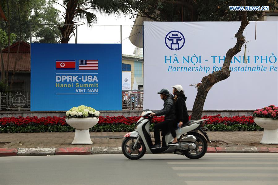 People pass by the International Media Center for the second summit between the Democratic People\'s Republic of Korea (DPRK) and the United States in Hanoi, Vietnam, on Feb. 24, 2019. The second DPRK-U.S. summit is scheduled to be held in Hanoi on Feb. 27-28. (Xinhua/Wang Di)