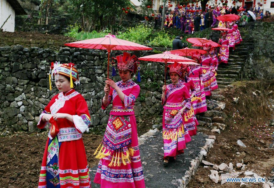 The bride is escorted by female friends to the bridegroom\'s home at a wedding ceremony in Mianhua Village of Siba Township of Luocheng Mulao Autonomous County, south China\'s Guangxi Zhuang Autonomous Region, March 17, 2019. A traditional wedding ceremony of the Mulao ethnic group is held here on Sunday. (Xinhua/Meng Zengshi)