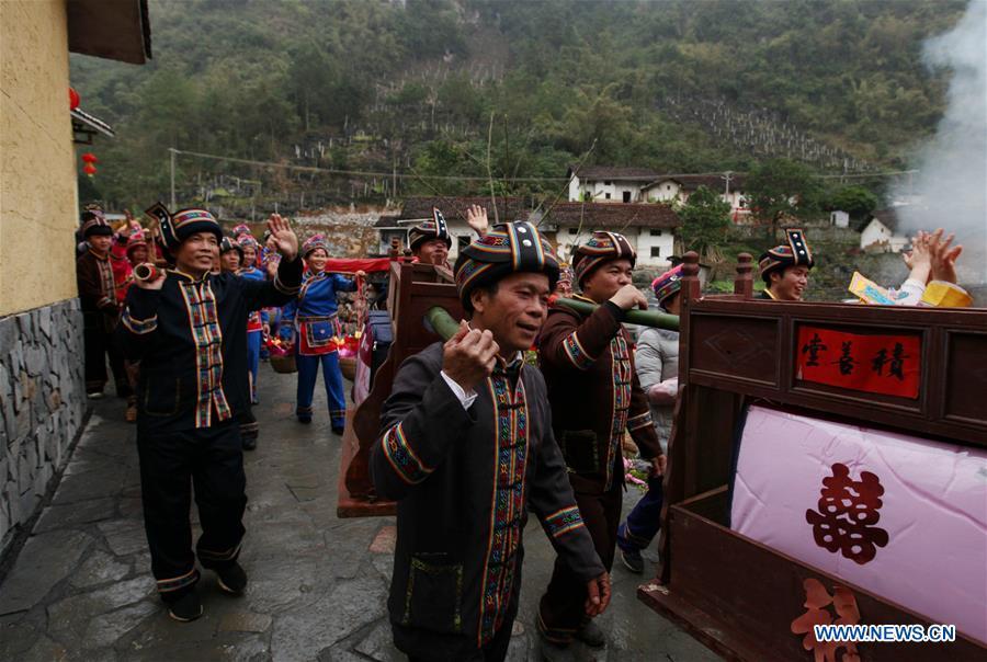 A team send dowries to the bridegroom\'s home at a wedding ceremony in Mianhua Village of Siba Township of Luocheng Mulao Autonomous County, south China\'s Guangxi Zhuang Autonomous Region, March 17, 2019. A tradit
