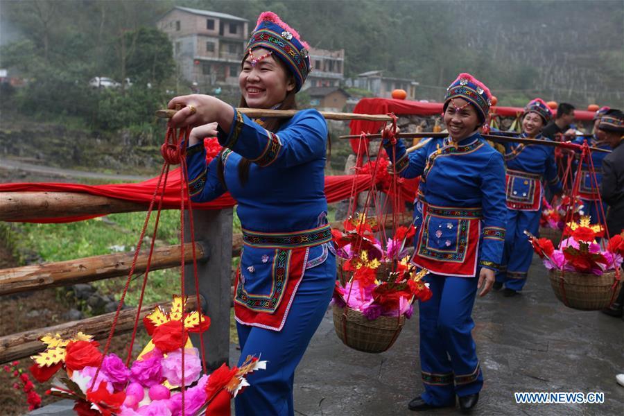 A team send dowries to the bridegroom\'s home at a wedding ceremony in Mianhua Village of Siba Township of Luocheng Mulao Autonomous County, south China\'s Guangxi Zhuang Autonomous Region, March 17, 2019. A traditional wedding ceremony of the Mulao ethnic group is held here on Sunday. (Xinhua/Meng Zengshi)