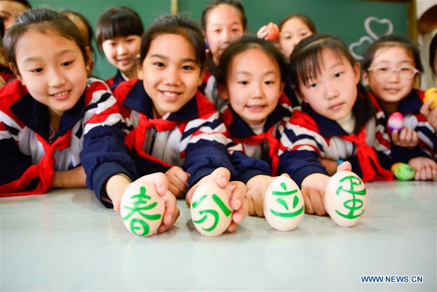 Students play a game to make eggs stand upright on end at a primary school in Handan, north China\'s Hebei Province, March 20, 2018, one day ahead of \
