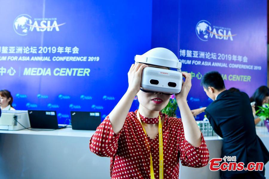 A reporter wears virtual reality (VR) goggles at the media center of the Boao Forum for Asia annual conference in Boao, Hainan Province, March 26, 2019. China Telecom showcased its 5G service at the media center, allowing 4K ultra-high-definition reports from the event, being held from March 26 to 29. Boao is one of two places in the island province where China Telecom is testing the 5G service. (Photo: China News Service/Luo Yunfei)